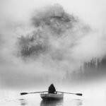 Tableau artistique Noir et Blanc "Sérénité" représentant un batelier sur un lac sur fond de montagne dans la brume